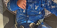 Huey is registered to the contest to win money with this photo: baby, infant, onesie, blue_clothing, baby_seat, cushion, straps, face, eyes, hand, legs, footwear, indoors, cute, child, portrait, expression, comfortable, baby_boy, closeup