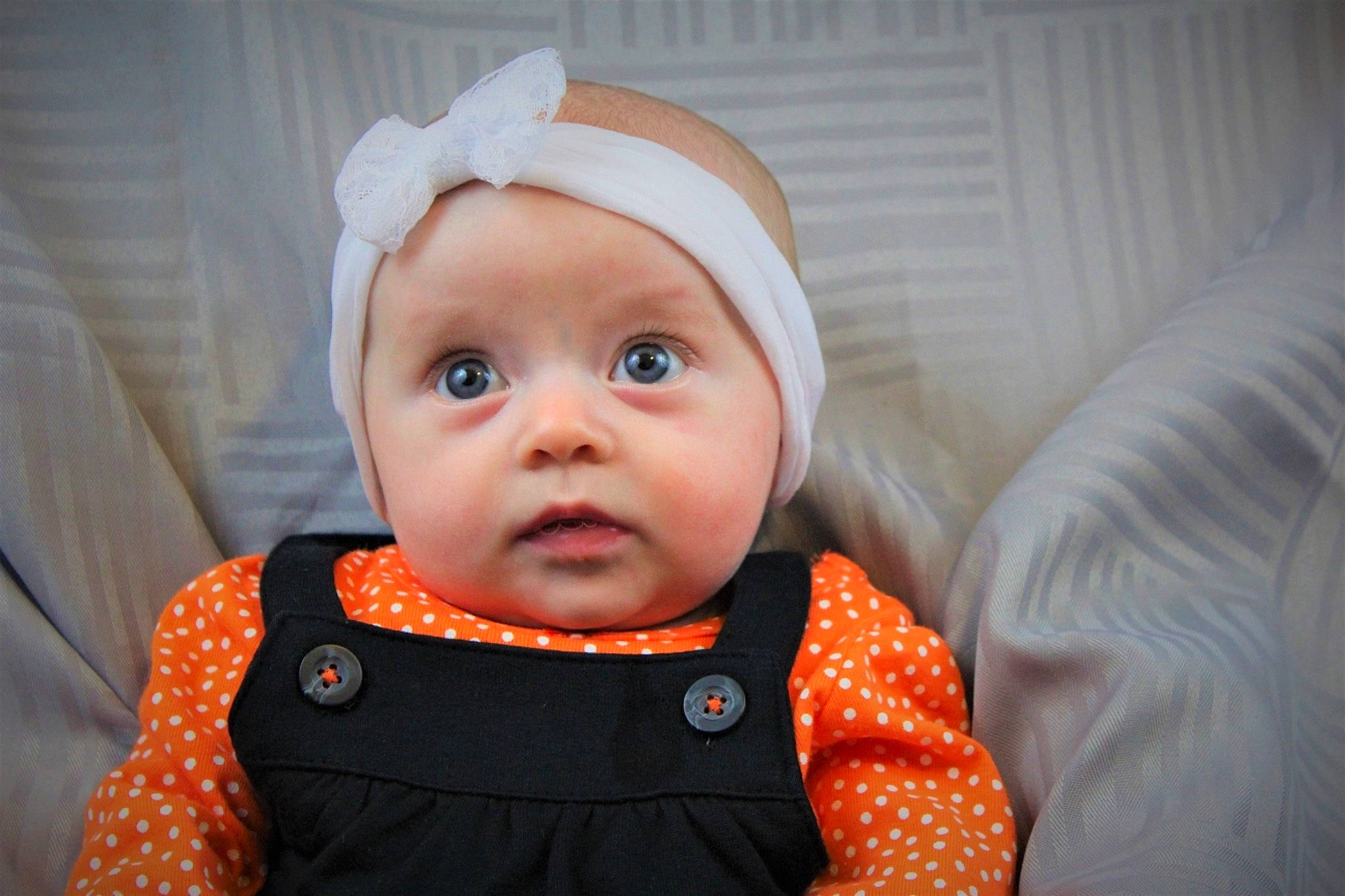 Tinley is registered to the contest to win money with this photo: baby, cheek, child, eye, face, hair_accessory, head, headgear, iris, lip, orange, person, skin, smile, toddler