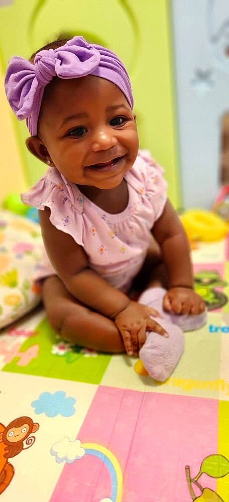 Taylor is registered to the contest to win money with this photo: baby, baby_toddler_clothing, cap, cheek, child, face, facial_expression, finger, flooring, fun, happy, headwear, joy, leisure, people, person, photograph, pink, product, skin