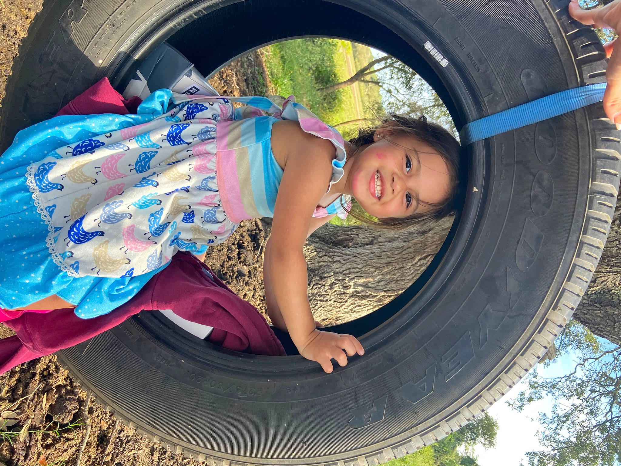 Brynleigh joined the competition — help win amazing prizes! automotive_tire, automotive_wheel_system, blue, cool, facial_expression, grass, happy, hubcap, joy, leaf, leisure, motor_vehicle, people_in_nature, person, plant, synthetic_rubber, tire, toddler, tread, tree