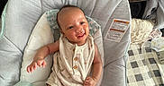 Amerious is registered to the contest to win money with this photo: baby, infant, smiling, baby_seat, romper, white_socks, bottle, cushion, blanket, pillow, indoor, happy, child, young, cute, relaxed, comfortable, portrait, person, home