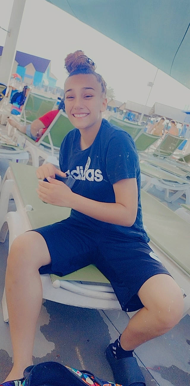 Lili is registered to the contest to win money with this photo: azure, chair, chest, elbow, electric_blue, fun, happy, human_leg, joy, knee, leisure, neck, person, physical_fitness, recreation, shorts, shoulder, sitting, smile, sportswear