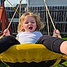 child, swing, playground, outdoor, backyard, grass, fence, rope, happy, blonde_hair, white_shirt, black_pants, sunlight, fun, motion, person, swing_set, wooden_frame, smile, excited