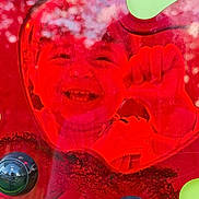Joud Rayan a rejoint le concours — aidez-le/la à gagner de superbes lots ! child, face, red, plastic, heart_shape, fist, smile, reflection, distortion, toy, colorful, closeup, happy, portrait, young, cheerful, glossy, translucent, background, playful