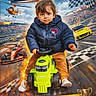 child, toddler, toy_tractor, jacket, race_track, racing_cars, helicopter, checkered_flag, fire_effect, trophy, race_poster, text_overlay, helmet_absent, crowd, stadium, yellow_car, red_car, blue_sky, clouds, brown_pants