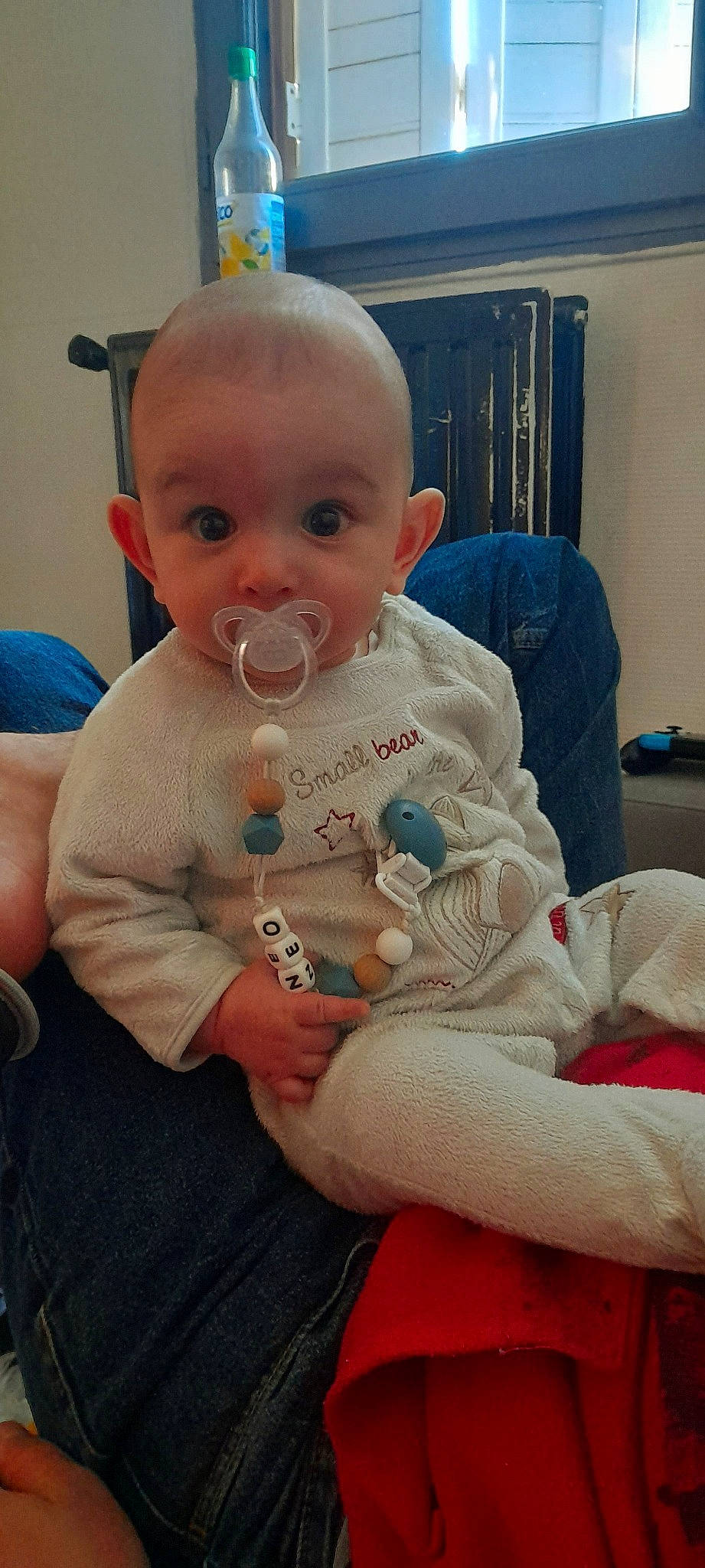 Neo a rejoint le concours — aidez-le/la à gagner de superbes lots ! baby, baby_toddler_clothing, blue, chair, cheek, comfort, drinkware, finger, hand, human_body, iris, lap, mouth, nail, nose, person, sitting, skin, sleeve, thumb