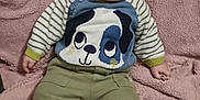 Lilio a rejoint le concours — aidez-le/la à gagner de superbes lots ! baby, child, infant, person, face, sweater, dog_design, pants, socks, blanket, soft_texture, striped_sleeves, cute, indoors, seated, looking_up, cozy, comfortable, young, casual_clothing
