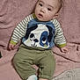 baby, child, infant, person, face, sweater, dog_design, pants, socks, blanket, soft_texture, striped_sleeves, cute, indoors, seated, looking_up, cozy, comfortable, young, casual_clothing