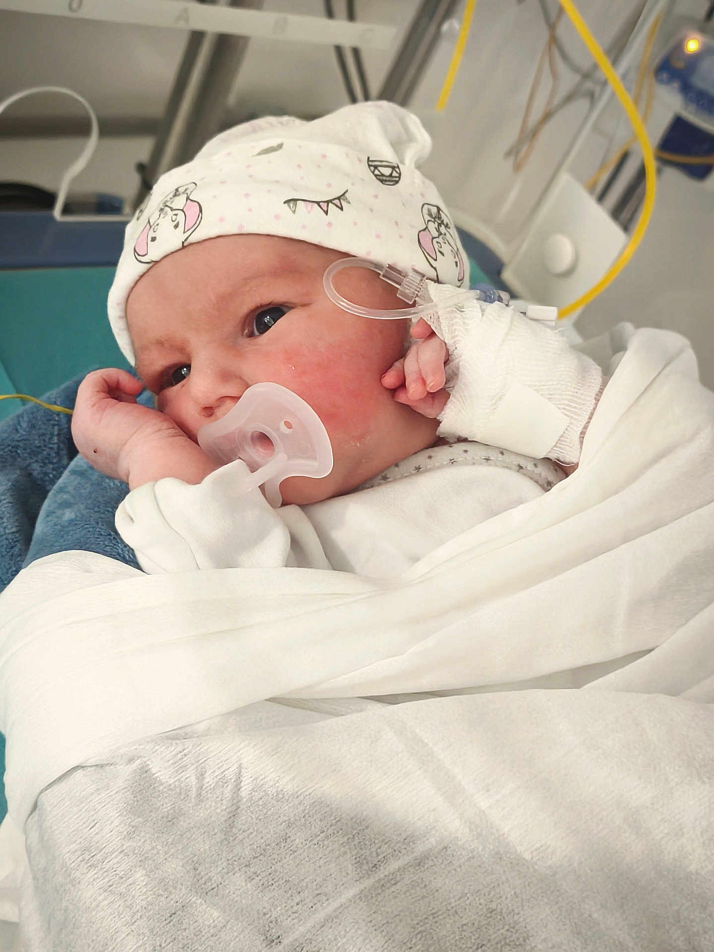 Chelsea participe au concours pour gagner de l'argent avec cette photo : baby, bandage, bed, blanket, crib, cute, eyes, face, hand, hat, hospital, infant, iv_line, mattress, medical_tubing, newborn, onesie, pacifier, patient, swaddled