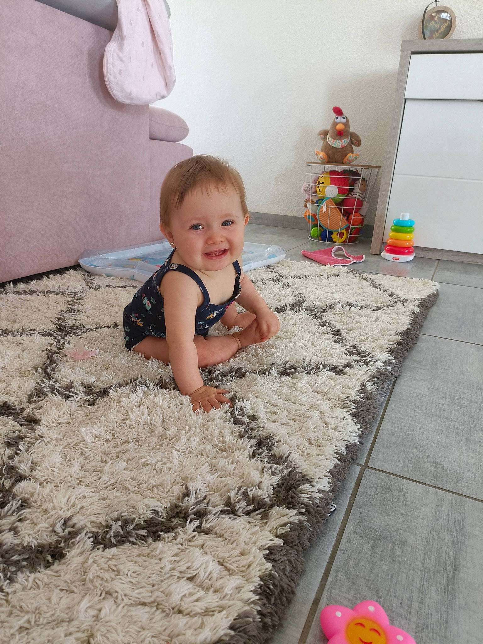 Olivia a rejoint le concours — aidez-le/la à gagner de superbes lots ! baby, baby_toddler_clothing, carpet, child, floor, flooring, fun, grass, happy, joy, pattern, people_in_nature, person, pink, play, red, smile, t_shirt, toddler, toy