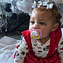 Amari joined the competition — help win amazing prizes! baby, child, pacifier, white_bows, red_dress, christmas_tree, ornaments, white_blanket, holiday_theme, indoor, cute, toddler, festive, decorations, sitting, curious, face, clothing, soft_toys, holiday