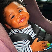 Daniel joined the competition — help win amazing prizes! baby, car_seat, child, smiling, striped_shirt, seatbelt, toy, happy, cute, infant, portrait, indoors, child_safety, person, car_interior, face, hand, young_child, seat, bright