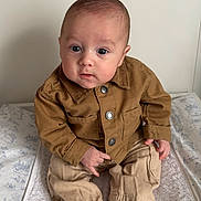 Jaden a rejoint le concours — aidez-le/la à gagner de superbes lots ! baby, bed, blanket, child, clothing, cute, expression, eyes, face, hands, head, indoor, infant, jacket, pants, portrait, sitting, skin, socks, young