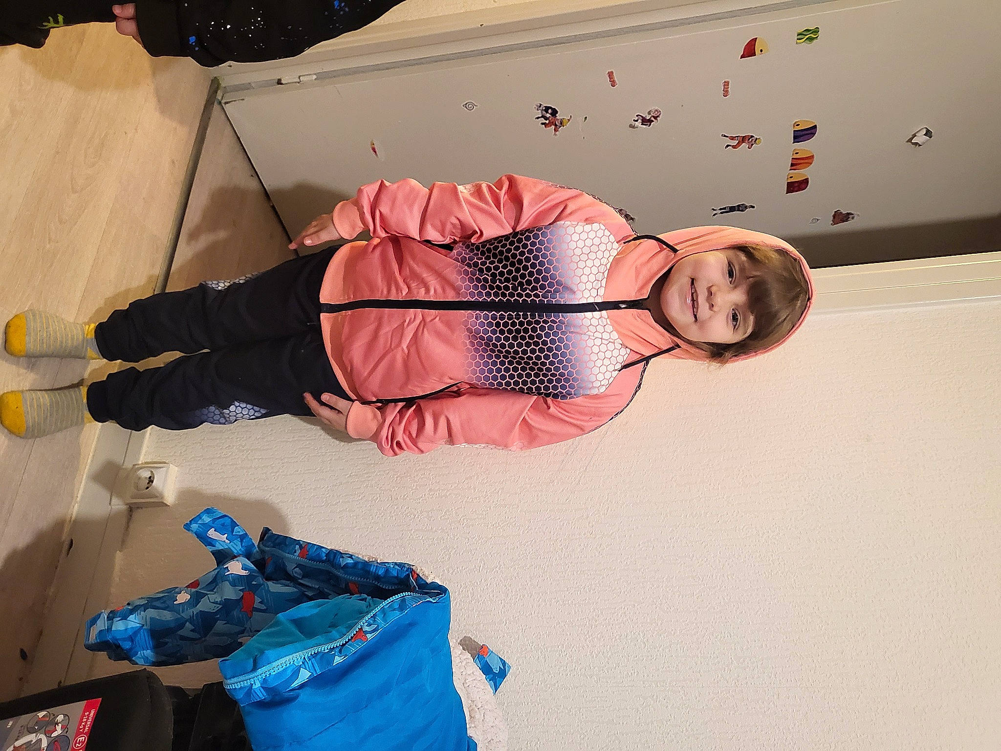 Emma a rejoint le concours — aidez-le/la à gagner de superbes lots ! backpack, bag, comfort, electric_blue, eyewear, flooring, fun, joy, knee, leisure, luggage_and_bags, outdoor_shoe, pattern, peach, person, recreation, room, sitting, walking_shoe