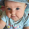 baby, child, hat, blue_eyes, polka_dot, shirt, toy, sitting, indoor, closeup, cute, infant, denim, face, expression, clothing, person, milestone, text_overlay, playful
