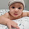 Emiliano is registered to the contest to win money with this photo: baby, beanie, blanket, child, closeup, curious, cute, expression, face, floral_pattern, hand, hat, indoors, infant, lying_down, person, portrait, skin, striped, young