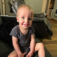 Christopher joined the competition — help win amazing prizes! toddler, child, smiling, blue_eyes, sitting, couch, gray_clothing, barefoot, living_room, wooden_floor, recliner, indoor, person, happy, short_hair, home, casual, furniture, playful, cute