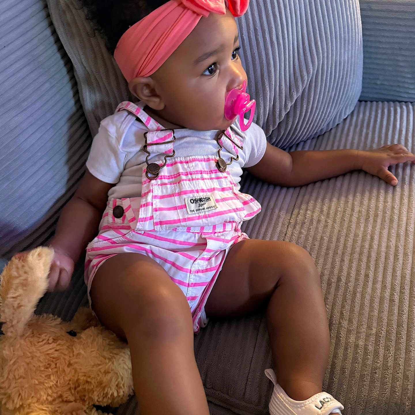 Talaija joined the competition — help win amazing prizes! baby, child, couch, curly_hair, cute, gray_couch, headband, indoor, overalls, pacifier, pink_headband, plush_toy, relaxed, seated, side_view, soft_lighting, striped_clothing, teddy_bear, toddler, white_sandals