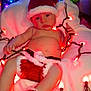 Eric is registered to the contest to win money with this photo: baby, infant, christmas, holiday, santa_hat, knitwear, red_lights, blanket, cute, festive, indoors, decorations, christmas_tree, holiday_lights, child, portrait, cozy, warm, celebration, smiling