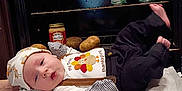 Eric is registered to the contest to win money with this photo: autumn, baby, baby_girl, blanket, canned_food, clothing, cozy, cute, food, hat, holiday, indoor, infant, kitchen, lying_down, oven, person, potatoes, soft_texture, thanksgiving