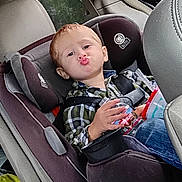 Dantyvious is registered to the contest to win money with this photo: child, toddler, car_seat, vehicle_interior, red_hair, puckered_lips, seatbelt, plaid_shirt, blue_jeans, cup, toy, window, tree_outside, car_door, car_seat_harness, child_safety, funny_face, indoor, person, seat