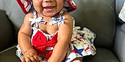 Harper is registered to the contest to win money with this photo: baby, blue, bracelet, child, cute, dress, feet, hands, happy, hat, indoors, infant, leather_couch, playful, portrait, red, sitting, smiling, stars, white