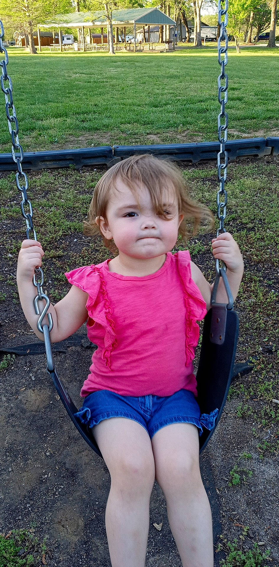 Allison is registered to the contest to win money with this photo: blue, chin, eye, face, facial_expression, finger, fun, green, hair, hand, happy, leg, leisure, person, photograph, pink, playground, standing, swing, toddler