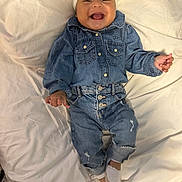 Keylee is registered to the contest to win money with this photo: baby, child, denim, jeans, shirt, headband, smiling, happy, infant, clothing, white_bed, footwear, shoes, baby_girl, portrait, cute, indoor, person, toddler, fashion