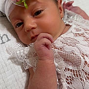 Kiara is registered to the contest to win money with this photo: baby, infant, headband, flower, lace, clothing, hand, face, skin, blanket, soft, newborn, portrait, cute, child, resting, pink, white, closeup, peaceful
