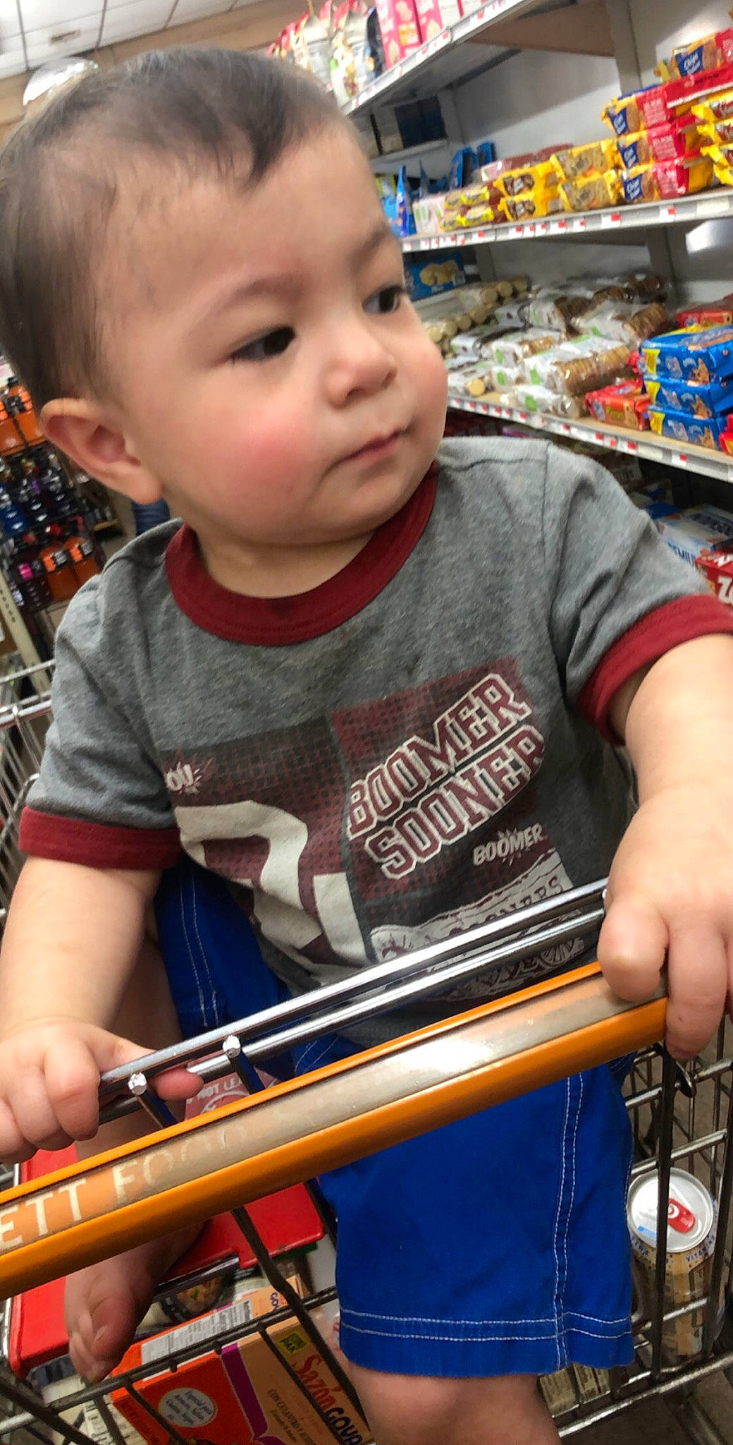 Marcus Jr. is registered to the contest to win money with this photo: baby, classical_music, convenience_store, ear, grocery_store, musical_instrument_accessory, person, retail, shelf, supermarket, toddler