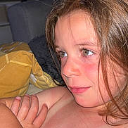 Mia participe au concours pour gagner de l'argent avec cette photo : child, face, portrait, indoor, hair, skin, expression, young, person, closeup, candid, natural, casual, sitting, furniture, blanket, comfort, relaxed, warm, light