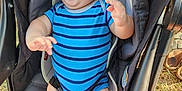 Finnegan is registered to the contest to win money with this photo: baby, child, blue_onesie, stroller, happy, smiling, outdoor, grass, sunlight, infant, seatbelt, person, cute, laughing, young_child, legs, hands, head, face, summer