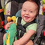 Finnegan is registered to the contest to win money with this photo: baby, car_seat, smiling, child, toy, stuffed_animal, corn_cob_toy, happy, infant, seatbelt, clothing, indoor, cute, holding, feet, hands, red_bracelet, fabric, child_safety, playful