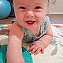 baby, smiling, crawling, child, play_mat, hand, face, indoor, floor, exercise_ball, happy, person, infant, skin, furniture, home, curly_hair, closeup, cute, young_child