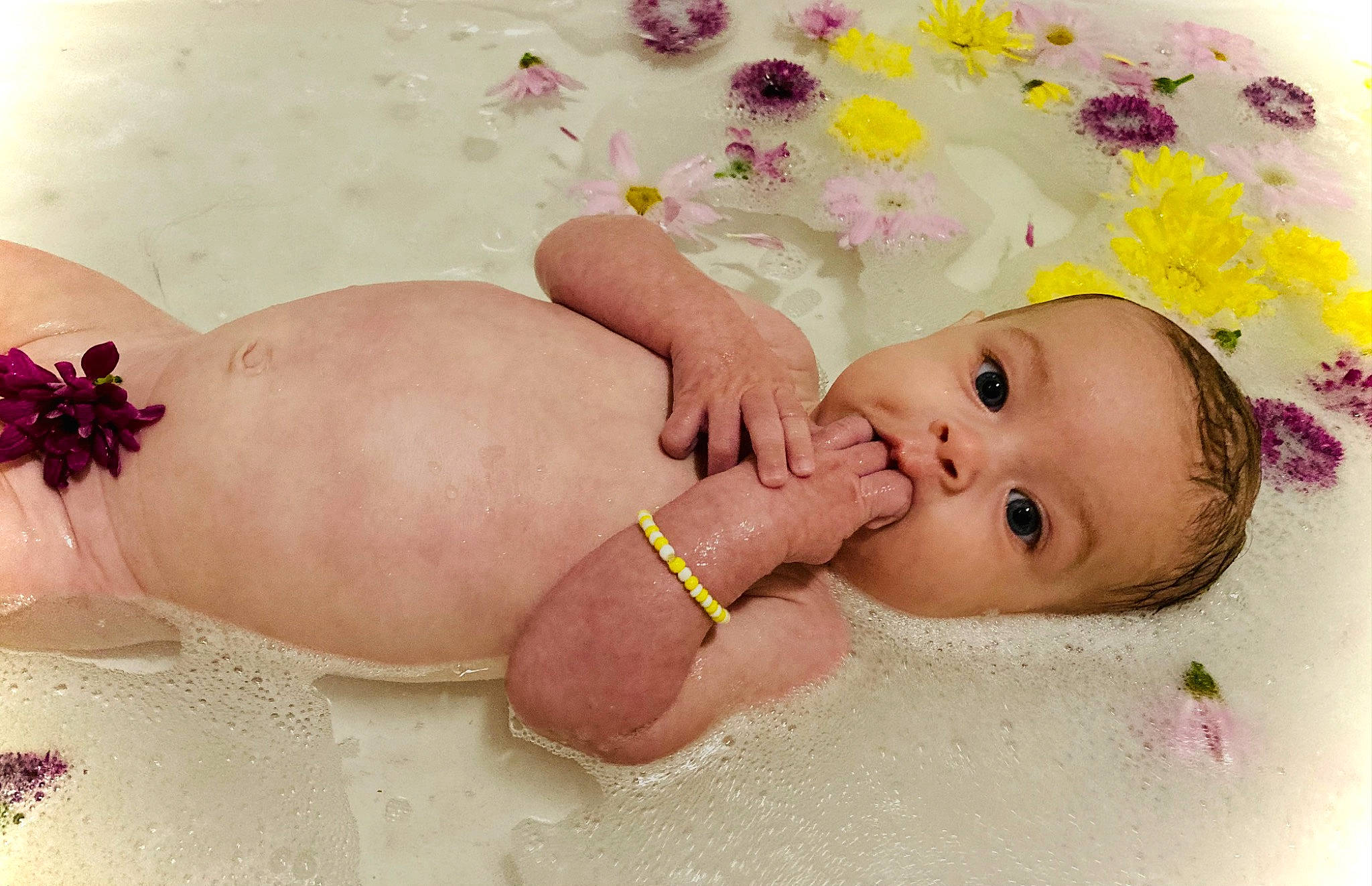 Alice is registered to the contest to win money with this photo: baby, baby_products, baby_sleeping, baby_toddler_clothing, bathing, cheek, chest, child, fashion_accessory, finger, foot, hair_accessory, happy, nail, person, petal, pink, skin, stomach, thumb