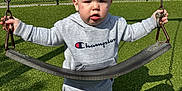 Beckham joined the competition — help win amazing prizes! toddler, child, swing, playground, outdoor, grass, clothing, hoodie, shorts, socks, daylight, sky, clouds, fence, chain, shadow, person, expression, park, recreation