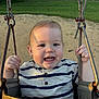 baby, child, toddler, swing, playground, smile, happy, outdoor, grass, sand, metal, clothing, striped_shirt, hands, face, sunlight, park, fun, play, joy