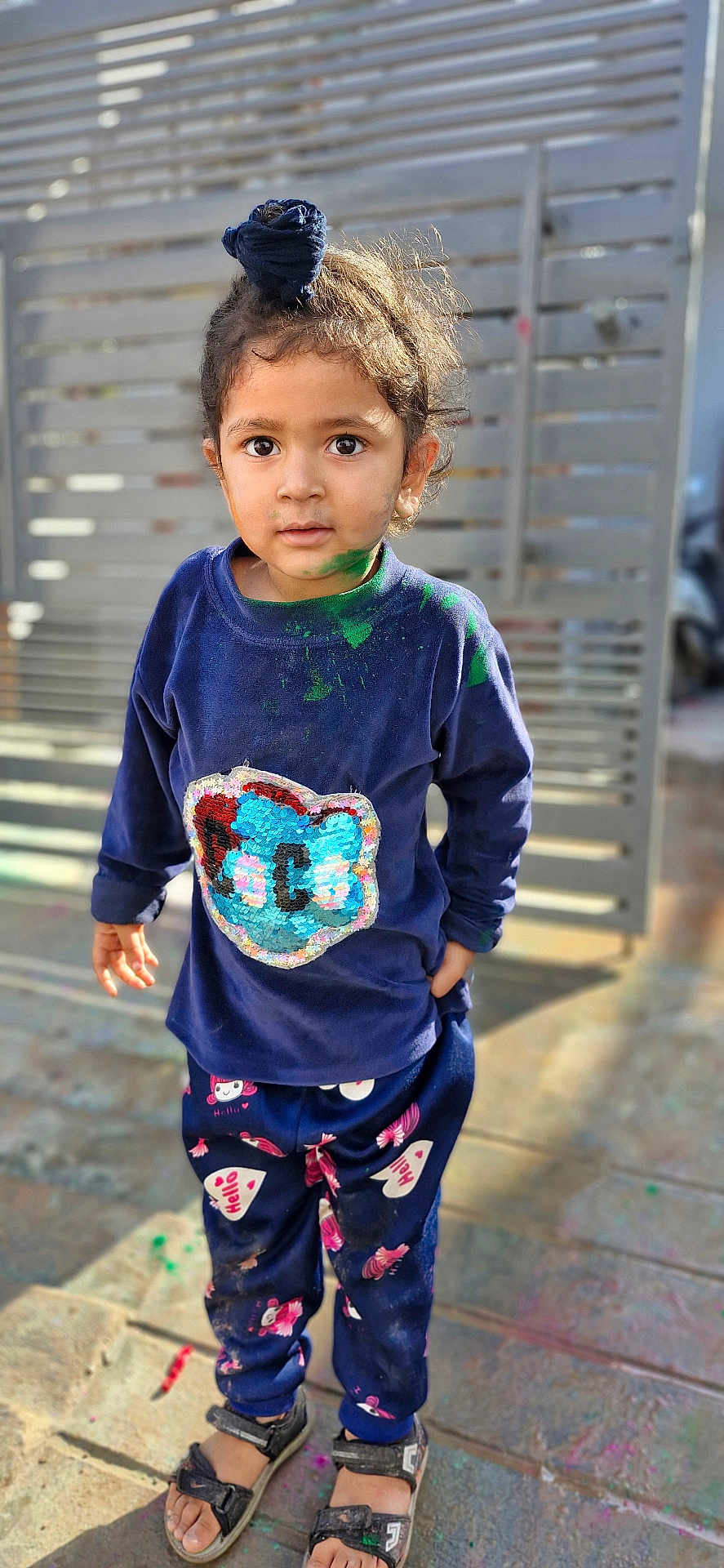 Gurfateh Singh joined the competition — help win amazing prizes! child, toddler, paint, messy, navy_blue, shirt, pants, sandals, top_knot, outdoor, sunlight, face, eyes, standing, expression, gate, pavement, clothing, casual, colorful