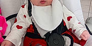 Alexia participe au concours pour gagner de l'argent avec cette photo : baby, baby_seat, bib, child, cute, expression, floor_tiles, heart_pattern, human, indoor, infant, looking_away, person, red_clothing, safety_harness, seat, soft_texture, tights, white_clothing, young_child