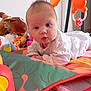 baby, baby_toys, child, colorful, crawling, curious, cute, face, floor, gaze, indoor, infant, playmat, playtime, plush_toy, portrait, soft_toys, toy, white_clothing, young_child
