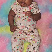 Leia is registered to the contest to win money with this photo: baby, infant, child, floral_outfit, hat, blanket, rainbow, colorful, cute, lying_down, portrait, soft_texture, clothing, pattern, face, skin, person, indoors, newborn, sleepwear