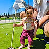 Anastasia joined the competition — help win amazing prizes! baby, child, golf, putting_green, flag, flagstick, grass, outdoor, sunny, smile, person, adult, support, clothing, barefoot, recreation, sport, happy, nature, daytime