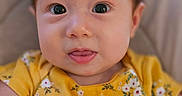 Anastasia joined the competition — help win amazing prizes! baby, child, face, portrait, yellow_clothing, floral_pattern, toy, colorful, cute, infant, closeup, expression, smile, skin, hair, eyes, indoors, soft_light, cozy, happy