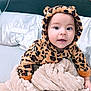 Eliam is registered to the contest to win money with this photo: baby, child, infant, hoodie, leopard_print, blanket, bed, cute, smile, face, eyes, fuzzy_clothing, soft_texture, indoors, cozy, warm, person, baby_clothes, headwear, expression