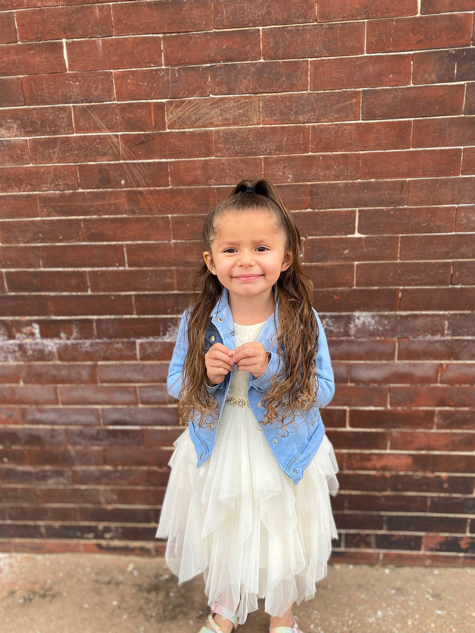 Laylani is registered to the contest to win money with this photo: baby_toddler_clothing, brick, brickwork, dress, electric_blue, face, flash_photography, formal_wear, grass, hair, happy, head, jewellery, joy, long_hair, pattern, person, pink, smile, toddler