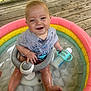 Kaelen is registered to the contest to win money with this photo: baby, infant, water, pool, inflatable_pool, sippy_cup, smile, happy, child, outdoor, wooden_deck, clothing, wet, sitting, toy, summer, play, cute, person, face