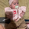 Willow joined the competition — help win amazing prizes! baby, infant, pacifier, headband, flower, pink_clothing, beige_pants, patterned_pillow, blanket, shoes, floral_shoes, clip, lying_down, indoors, cute, child, person, small_hands, soft_lighting, sleepwear