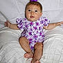 Mylee joined the competition — help win amazing prizes! baby, child, purple_bow, floral_outfit, cushion, knitted_blanket, white_background, sitting, cute, chubby_legs, happy, indoors, portrait, infant, smiling, blue_eyes, curious, clothing, soft_texture, comfortable