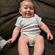 Mylee joined the competition — help win amazing prizes! baby, child, smile, tongue, onesie, couch, brown, texture, happy, cheeks, infant, skin, legs, arms, furniture, indoor, person, cute, portrait, playful