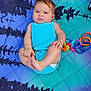 Mylee joined the competition — help win amazing prizes! baby, infant, blue_onesie, colorful_blanket, toy_rings, footwear, shoe, leaf_pattern, outdoor, cute, child, person, skin, face, hands, feet, playtime, summer, relaxing, lying_down